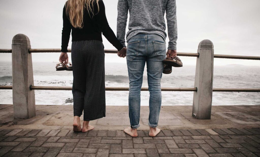 pareja tomadas de la mano en un muelle